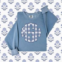 Perfect for chilly beachy nights or to look cute while being casual, this Preppy Blue Monogrammed sweatshirt will be a favorite for years to come! It also makes the best bridesmaid gift or for the "coastal grandmother" in your life. The floral block print is loved by many! This custom crewneck sweatshirt brings both incredible quality and amazing style to the mix. Made with soft, ring-spun cotton fabric with 100% cotton threads, it sits unmatched when it comes to softness. All sweatshirts featur Blue Crew Sweatshirt With Embroidered Graphics, Blue Relaxed Fit Cotton Sweater, Blue Relaxed Fit Sweatshirt With Embroidered Graphics, Casual Monogram Print Sweatshirt For Winter, Casual Monogram Print Sweater For Fall, Blue Crew Sweatshirt For Spring, Blue Crew Neck Spring Sweatshirt, Blue Crew Neck Sweatshirt For Spring, Blue Sporty Sweatshirt With Embroidered Graphics