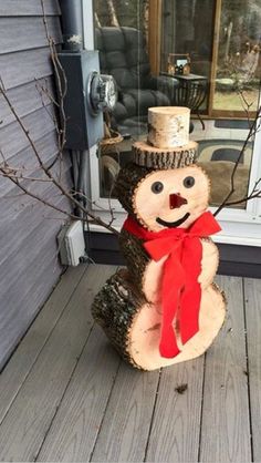 a wooden snowman sitting on top of a porch