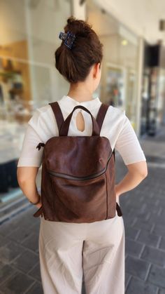 A just-right leather backpack with a minimalist silhouette, this rich - leather backpack features geometric cut with a deep, lined interior with 2 large departments, a zipper pocket, adjustable strap and a antique gold hardware for an chic updated finishing touch. Features: *  1 Interior large zipped pocket * Outside zipper pocket in the back of the bag   * Fully lined with strong Black cotton * 2 departments * Adjustable shoulder strap * zipper closure  ◄ DIMENSIONS ►  Height: 32 cm/ 12.5'' Wid Modern Brown Backpack For On-the-go, Brown Leather Backpack With Zipper Closure, Brown Leather Backpack With Zipper Pocket, Modern Brown Backpack For Daily Use, Modern Brown Leather Backpack With Leather Lining, Modern Brown Soft Leather Backpack, Modern Brown Backpack For Everyday Use, Modern Leather Backpack, Modern Brown Everyday Backpack