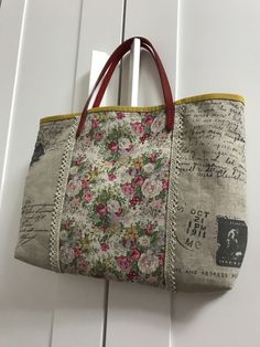 a floral bag hanging on the side of a white door with writing and flowers all over it