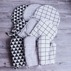 four oven mitts are laid out on the floor with black and white squares all over them