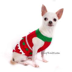 a small white dog wearing a red and green sweater with christmas decorations on it's chest