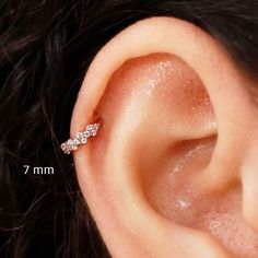 a woman's ear is shown with three small diamonds on the end of it