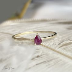 One piece of delicate 14K yellow gold pear shape, solitaire natural ruby stone promise ring  This ring can be perfectly stacked with the below ring from our store: https://etsy.me/3h4pNni * Metal: 14K solid gold * Stone: 4x3mm natural ruby * Band thickness: 1mm * Stamp: 14K * Guaranteed Authentic Solid Gold, Not Plated or Filled ❤️Follow us on Instagram @ elekalonjewelry for latest projects and designs. *If you have any questions, please feel free to message us. Pear Cut Ring, Ruby Bands, Ring Ruby, Ruby Engagement Ring, Ruby Stone, Gold Stone, Delicate Rings, Ruby Ring, Natural Ruby