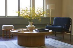 a living room filled with furniture and a vase on top of a wooden coffee table