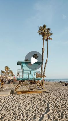 a lifeguard stand on the beach with palm trees