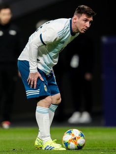 the soccer player is getting ready to kick the ball on the field with his hands