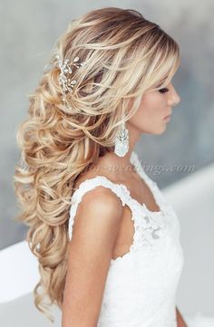 a woman with long blonde hair wearing a white dress and pearls in her hair is looking off to the side