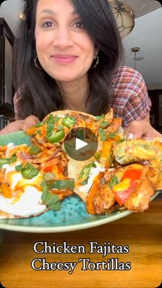 a woman holding a plate with chicken fajitas and cheese tortillas on it