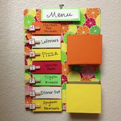 a colorful menu board hanging on the wall next to a clipboard with words written on it