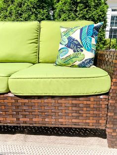 a green couch sitting on top of a patio