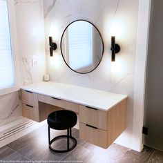 a bathroom with a vanity, stool and round mirror on the wall next to it