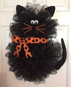 a black cat wreath with orange polka dots on it