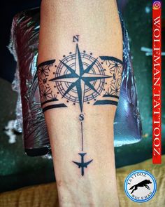 a black and white compass tattoo on the leg