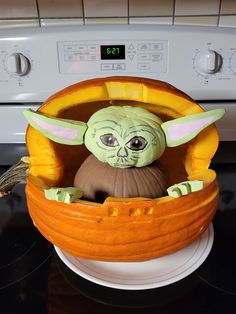 a star wars yoda in a pumpkin bowl on top of an appliance