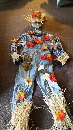 a scarecrow made out of old jeans and fake flowers