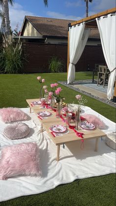 a table set up with pink flowers and plates