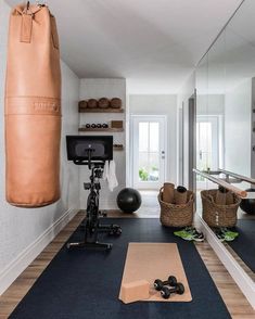 a home gym with exercise equipment and yoga mats on the floor in front of a mirror