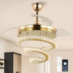 a chandelier hanging from the ceiling in a living room with a remote control