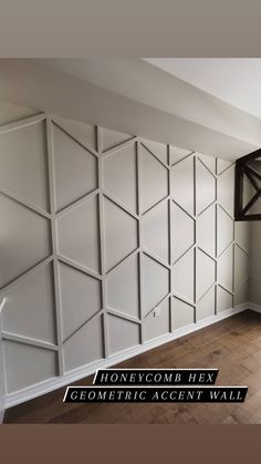 an empty room with wood flooring and white wall paneling on the walls is shown