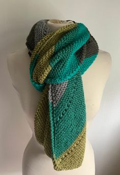 Hand knit unisex scarf Knitted in diagonal in various tone of green and gray Total length 74 inches Wide 12 inches Casual Green Winter Shawl, Green Hand Knitted Shawl For Winter, Green Winter Scarves One Size, Green Scarves For Winter, Green Knitted One-size Scarves, Green Knitted Scarf One Size, Green Knitted Scarf For Winter, Handmade Green Scarf For Winter, Handmade Green Winter Scarves