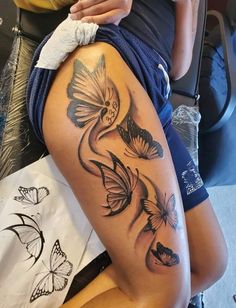 a woman with butterflies on her thigh