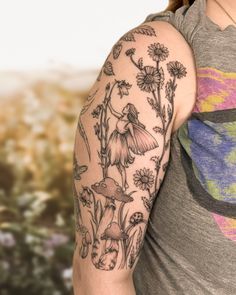 a woman's arm with flowers and mushrooms tattooed on the left side of her arm