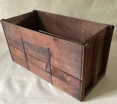 an old wooden crate sitting on top of a white sheet