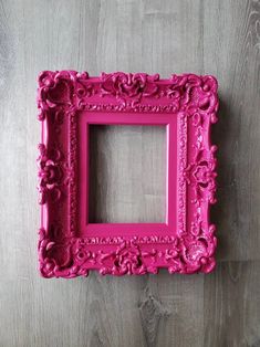 a pink frame sitting on top of a wooden floor