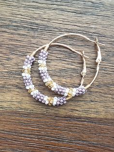 Hoop earrings with a mix of purple, gold and white beading. Lever back. -large hoops 2"x2" -medium hoops 1.5"x1.5" -small hoops 1.25x1.25 -extra small hoops 1x1 -mini hoops .75x.75 Purple Earrings, Earrings Beaded, Beaded Hoops, Amethyst Earrings, Jewelry Earrings Hoops, Purple Gold, Earrings Gold, Beaded Earrings, Gold Earrings