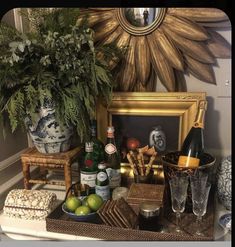 a table topped with bottles and glasses next to a potted plant