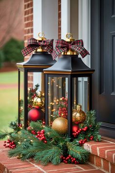 two black lanterns with christmas decorations on them