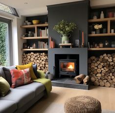 a living room filled with furniture and a fire place in front of a fireplace covered in logs