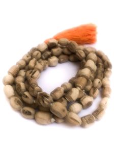 Tulsi (Tulasi) japa mala made from hand carved beads, hand knotted on white cotton thread, in Vrindavan, India. The beads are approximately 6mm to 9mm, with Large orange-colored cotton tassel. Total length is approximately 40 - 48 inches. Vrindavan grown, Vrindavan crafted.™ Use japa mala necklace as is, either as a necklace, prayer beads or a bracelet wrapped approximately six times around your wrist or use the beads for other crafting projects. The name "Tulasi" means "she who is incomparable. Bohemian Hand-strung Mala For Rituals, Bohemian Mala With Large Beads For Meditation, Traditional Handmade Mala For Meditation, Bohemian Mala With Wooden Beads For Puja, Bohemian Wooden Beads Mala For Puja, Bohemian Hand-strung Mala For Puja, Traditional Hand Knotted Mala For Meditation, Traditional Hand Knotted Mala For Rituals, Traditional Natural Beads As A Gift