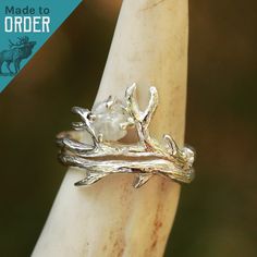 We are excited to introduce THE BUNDOLYN! We worked with an amazing artisan out of California to make this handmade beauty. This ring features a stunning raw, natural diamond surrounded by a beautiful and unique Sterling Silver bud branch. 2 rings included in this set. The band is hand-formed from a sheet of sterling silver and wire to create a stunning authentic design. ABOUT THIS RING Gemstones: Natural Raw Diamond Metal: Sterling Silver Color/Finish: Silver, Polished QUESTIONS ABOUT SIZING Go Antler Engagement Ring, Antler Rings, Antler Wedding Band, Deer Antler Ring, Hunter Wedding, Antler Ring, Engagement Ring For Her, 2 Rings, Engagement Sets