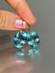 Gorgeous sparkly sky blue aquamarine earrings. The Faceted oval drops are flawless and have a beautiful sky blue color. The drops are attached to 14K18K SOLID GOLD ear wires. The earrings are elegant and have a lux look.  A truly gorgeous pair of earrings.  14K SOLID GOLD ear wires are being used, the ear wire ends are hand-stamped as proof of being 14K solid gold. In addition, extra work was done at the end of the ear wires to prevent any sort of pain or injury while inserting them through the ear lobes. **The 14K WHITE solid gold ear wires are RHODIUM plated to prevent tarnish of the ear wires over time. * Quality: Superb AAA+ FlawlessAquamarine * Carat (26 ct.) * Stone Shape: Facet Oval Shape * The dimension of stones: 18mm X 13mm / 0.7X 0.5 inch  * Metal: 24K Gold Vermeil/ 14K SOLID GO Oval Aquamarine Light Blue Jewelry, Faceted Yellow Gold Oval Earrings, Yellow Gold Faceted Oval Earrings, Oval Light Blue Aquamarine Jewelry, Light Blue Oval Aquamarine Jewelry, Blue Oval Topaz Earrings, Blue Topaz Oval Earrings, Luxury Oval Blue Topaz Earrings, Gold Oval Blue Topaz Earrings