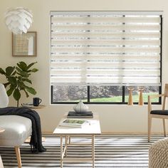 a living room filled with furniture and a window covered in blinds