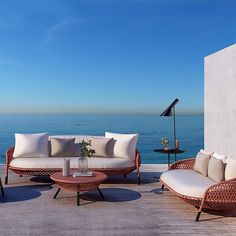 an outdoor seating area with wicker furniture overlooking the ocean