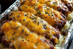 some meat covered in cheese on top of mashed potatoes