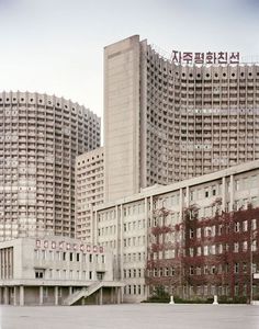 an empty parking lot in front of tall buildings with chinese writing on the top and bottom