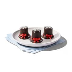 three pieces of chocolate cake on a plate with red ribbon around the edges and white frosting