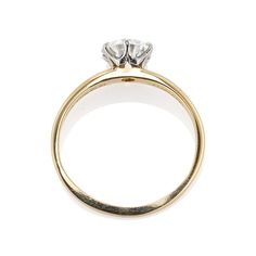 an 18ct yellow gold ring with a round brilliant cut diamond in the center, on a white background