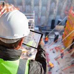 a construction worker looking at plans on his tablet