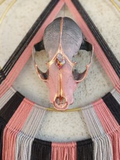 an animal's head is mounted to the side of a wall with fringes