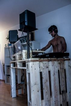 a man that is standing in front of a dj's turntable on a wooden table