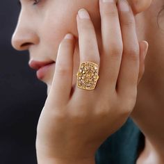 a woman wearing a gold ring with yellow diamonds on it's fingers and her hand