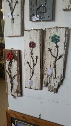 several pieces of wood with flowers are hanging on the wall in front of a store