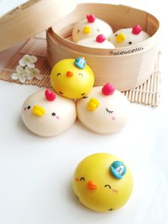 four yellow rubber ducks sitting next to each other on a white surface with a wooden container