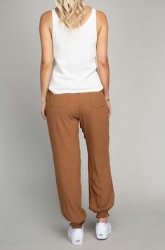 Designed for all-day comfort, these Brown Jogger Pants are crafted from a lightweight crinkle-textured fabric with no stretch. An elastic waistband and string drawstring at the waist provide a secure fit, while smocking at the ankle cuffs offers a flexible fit. Two side pockets in the front and two pockets in the back make it easy to store your small essentials. Comfortable Brown Bottoms For Spring, Brown Relaxed Fit Pants For Vacation, Brown Relaxed Fit Pull-on Pants, Casual Brown Drawstring Bottoms, Comfortable Brown Pants For Spring, Brown Bottoms With Elastic Waistband And Loosely Fitted Hips, Brown Trousers With Elastic Waistband, Loosely Fitted Brown Bottoms With Elastic Waistband, Brown Pants With Pockets For Vacation