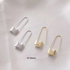 three pairs of gold and silver ear clips on white fabric with measurements for each pair